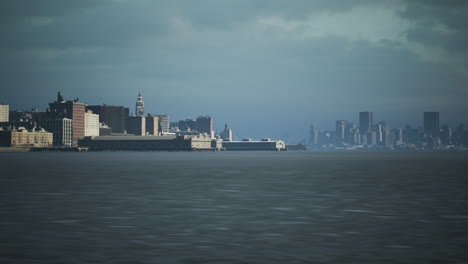 view of a city skyline against a cloudy backdrop near the waterfront at dusk