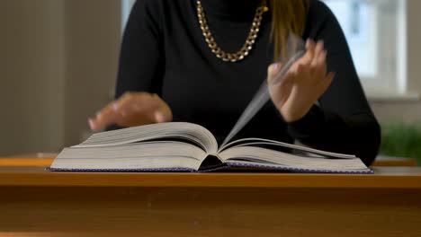 woman reading an open book at a desk