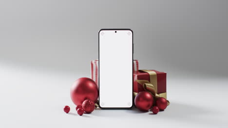 Vídeo-De-Regalos-De-Navidad,-Adornos-Y-Smartphone-Con-Espacio-Para-Copiar-Sobre-Fondo-Blanco.