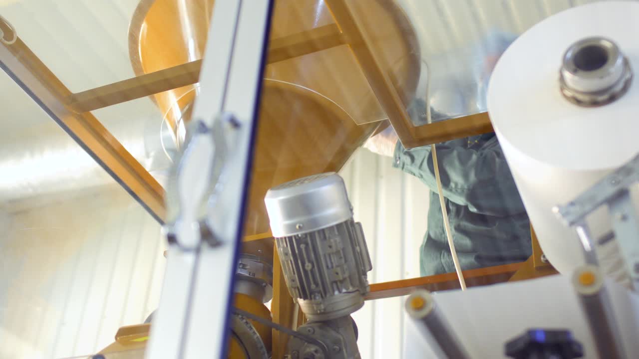 Worker pour out dry tea into machine