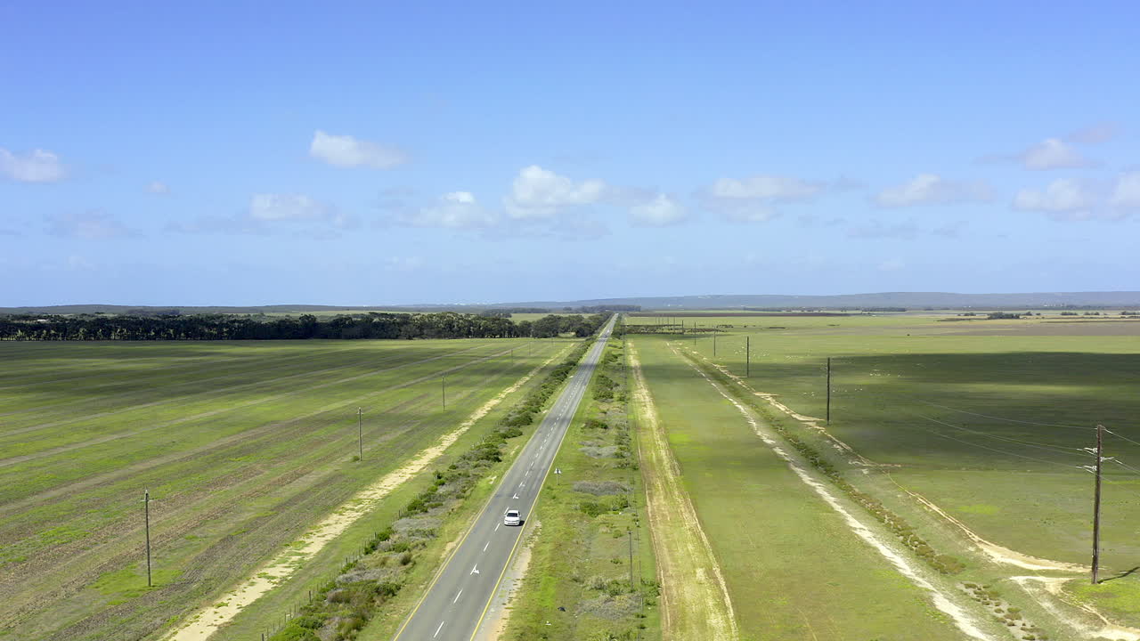 4k 드론 영상으로 자동차가 나라를 가로질러 운전하고 있습니다.