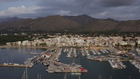 AERIAL:-Small-City-with-Port-on-Tropical-Island,-early-morning-with-Boats-and-Ocean-at-Small-Town-at-Sunrise-with-Mountains-in-Background-Vacation,-Travel,-Sunset