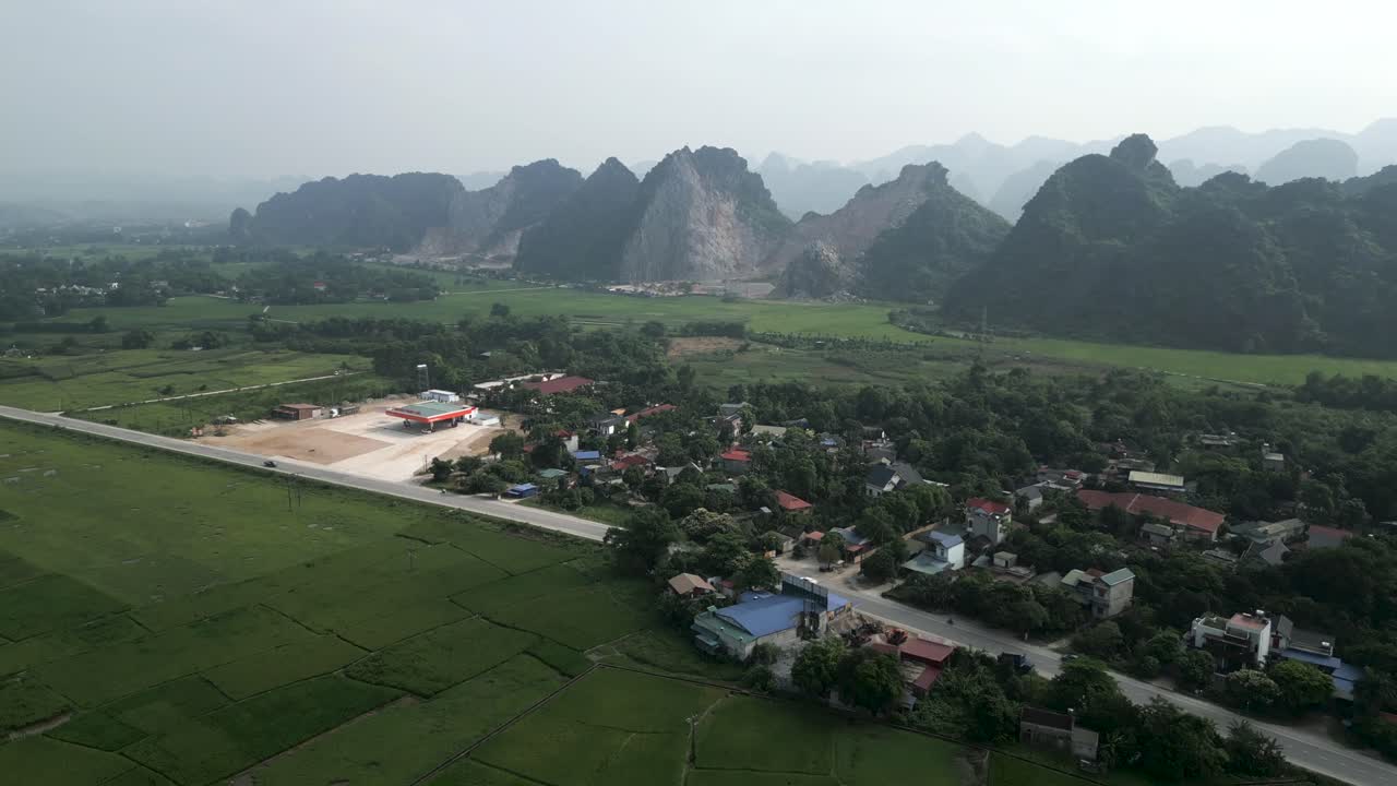 Aerial View of a Rural Vietnamese Village with Mountains in the Background