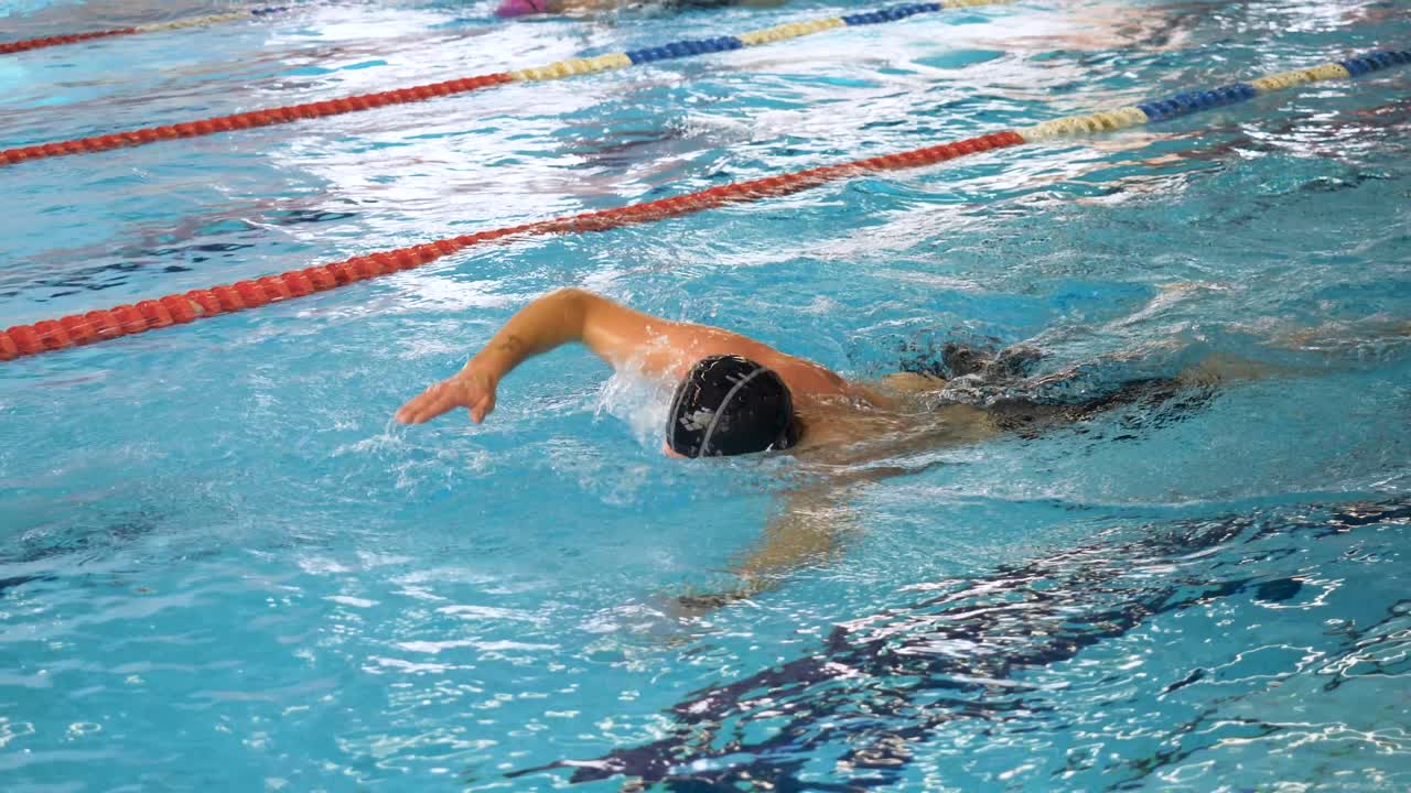 실내 수영장에서 수영하는 남자