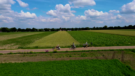 Ciclistas-En-Bicicleta-Entre-Hermosos-Campos-Verdes-En-El-Típico-Paisaje-Holandés