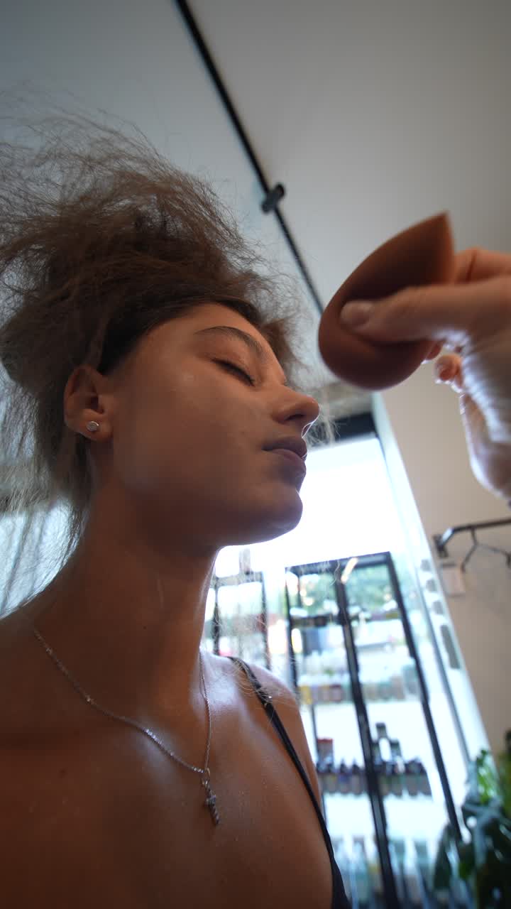 Young Woman Getting Makeup Applied with a Sponge