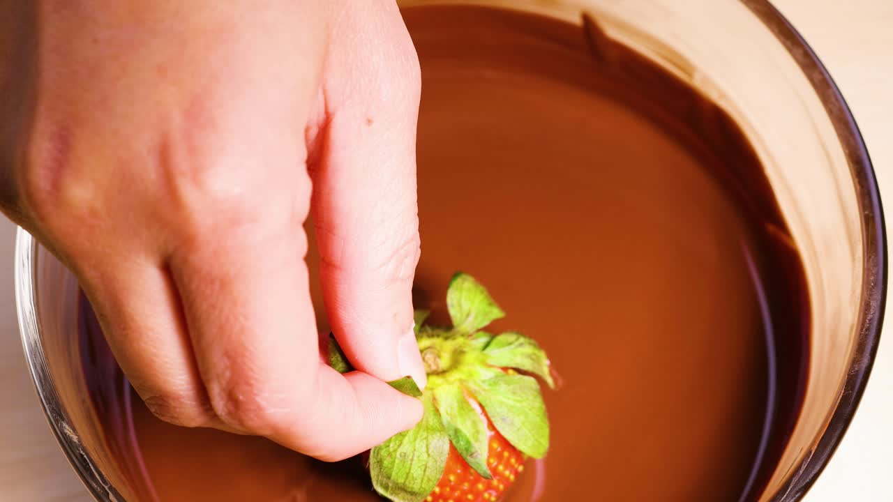 녹은 초콜릿 에 딸기 를 담그고 있는 것