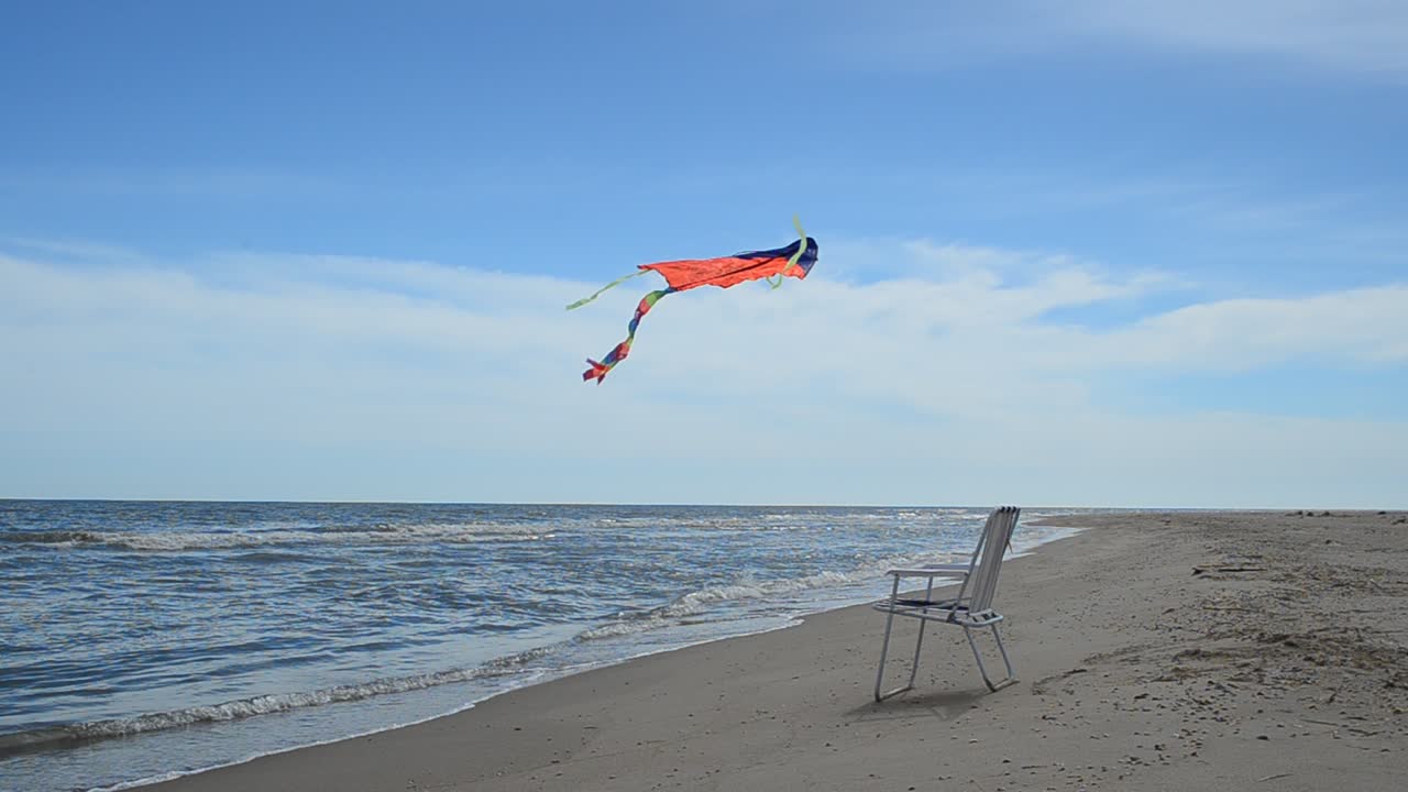 Tumbona en la playa, el mar y una cometa. Tiempo de verano en la orilla del mar.