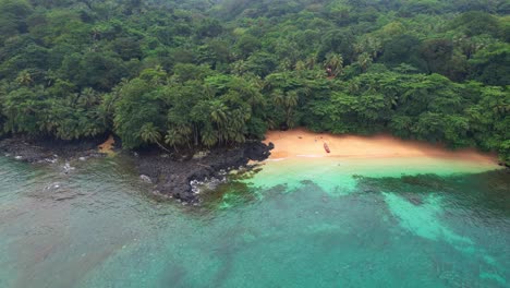 flying backwards with a woman entering the water with a boat on the beautiful margarida beach at ilha do principe (prince island) são tomé,africa