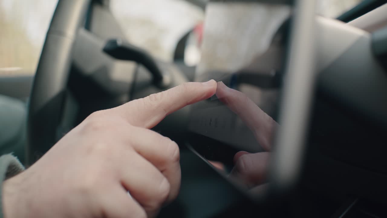 Close up of hands swiping on a touchcreen in an electric car