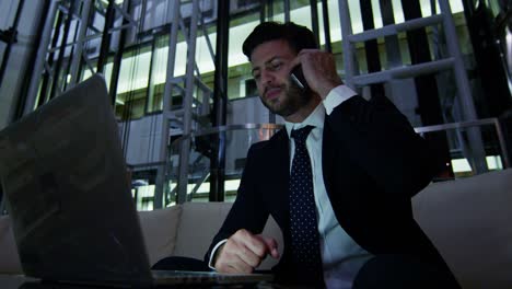 un hombre de negocios del medio oriente trabajando con una computadora portátil y un teléfono inteligente.