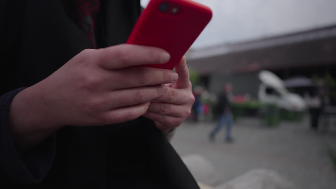 세련된 선글라스를 입은 여자가 휴대전화로 문자 메시지를 보내고 있습니다.