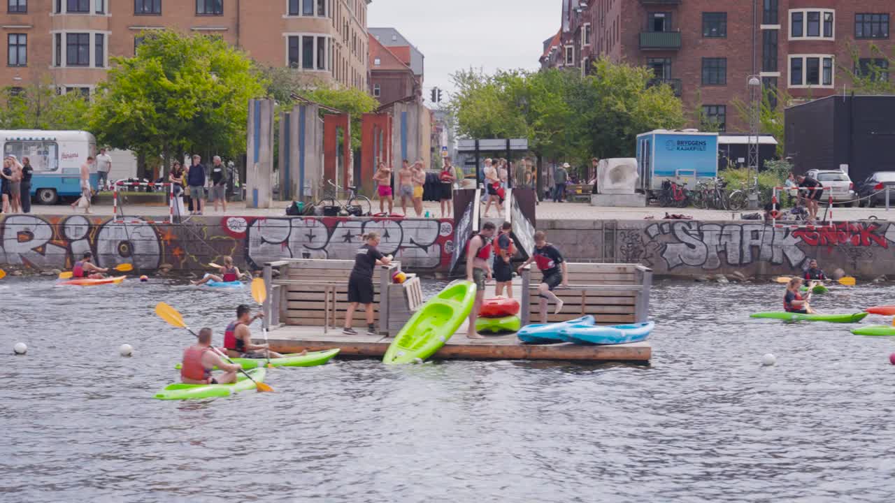 Canoe boat enthusiast gather in city canal near embankment, Copenhagen