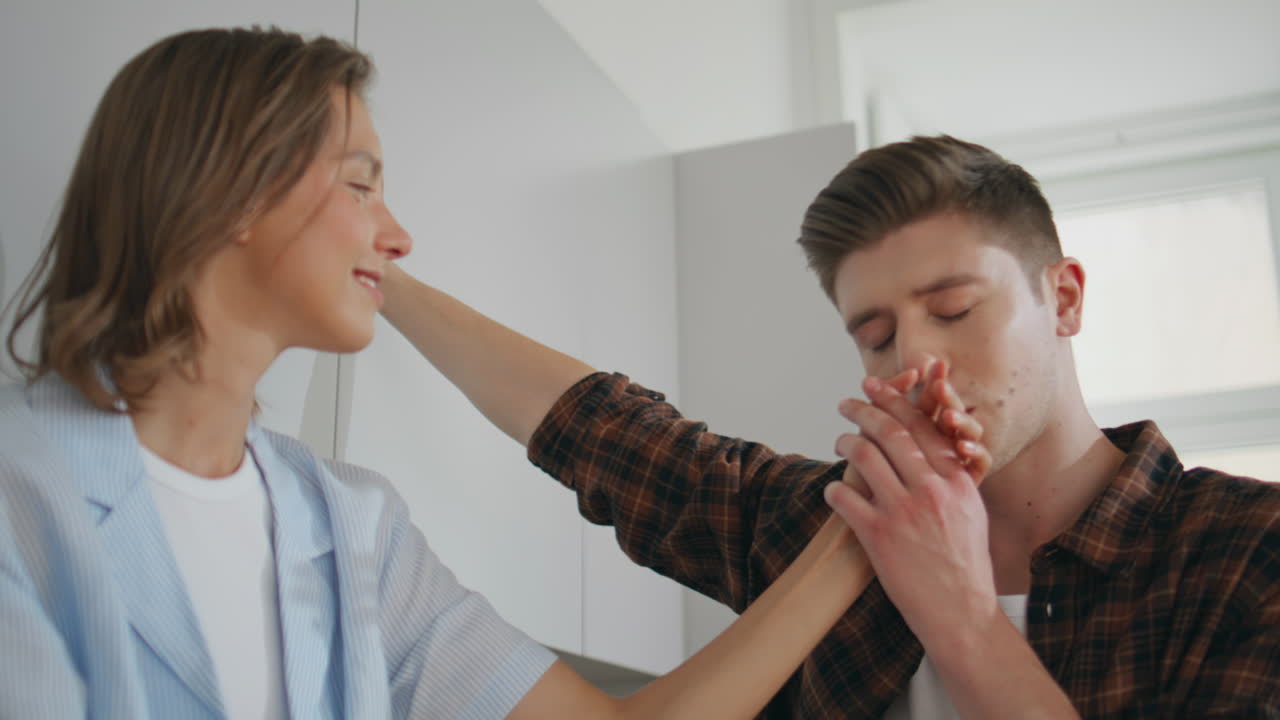 Affectionate people looking eyes enjoying time together. Loving man kissing hand