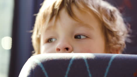 Little-boy-behind-seat-in-the-bus