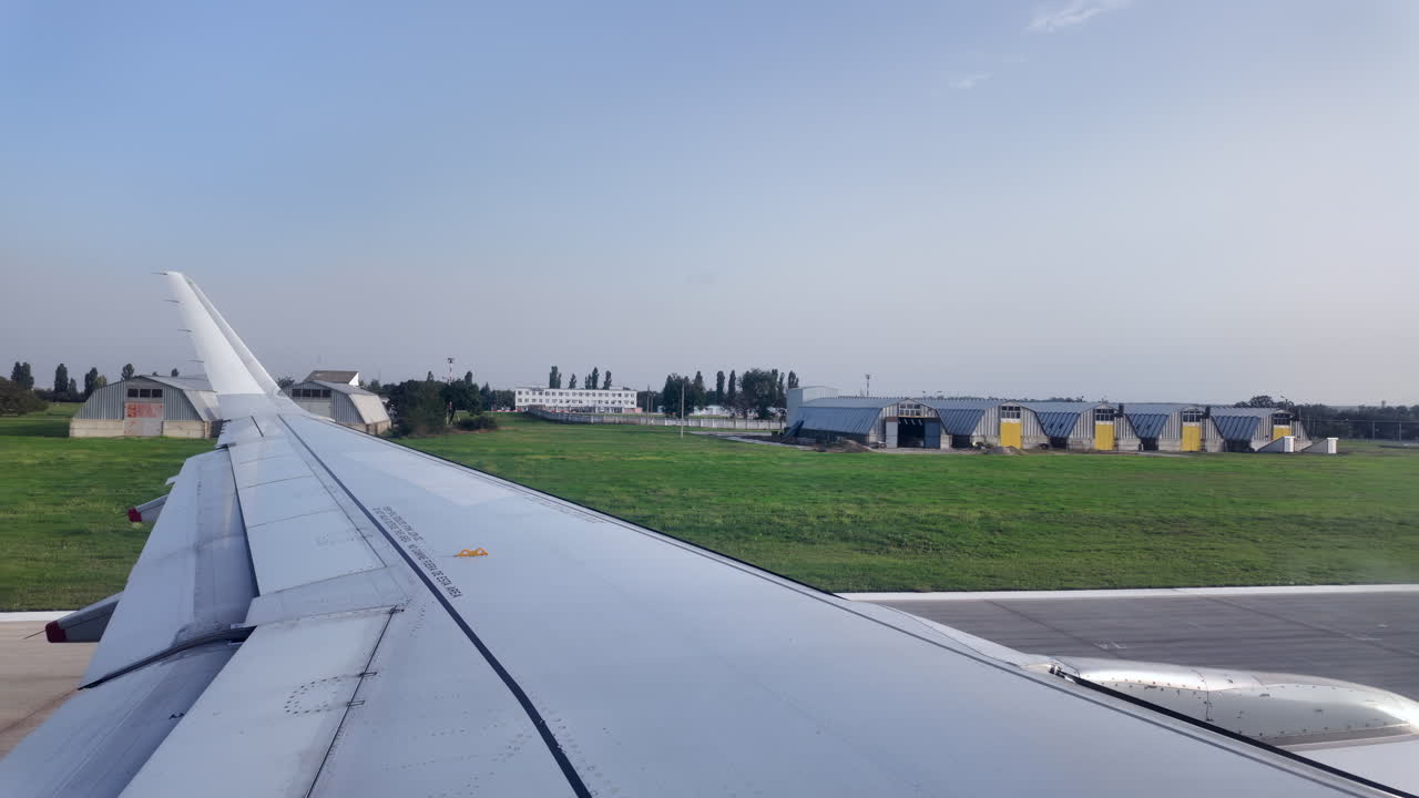 Chisinau, Moldavia - 12 luglio 2025: vista dell'ala dell'aereo dal finestrino che si muove attraverso l'Aeroporto Internazionale di Chisinau