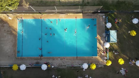 overhead shot of public blue swimming pool at club of buenos aires city at sunset