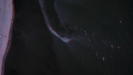 top down drone shot rising above sandbanks and shallow sea, sunny evening in kalajoki, finland