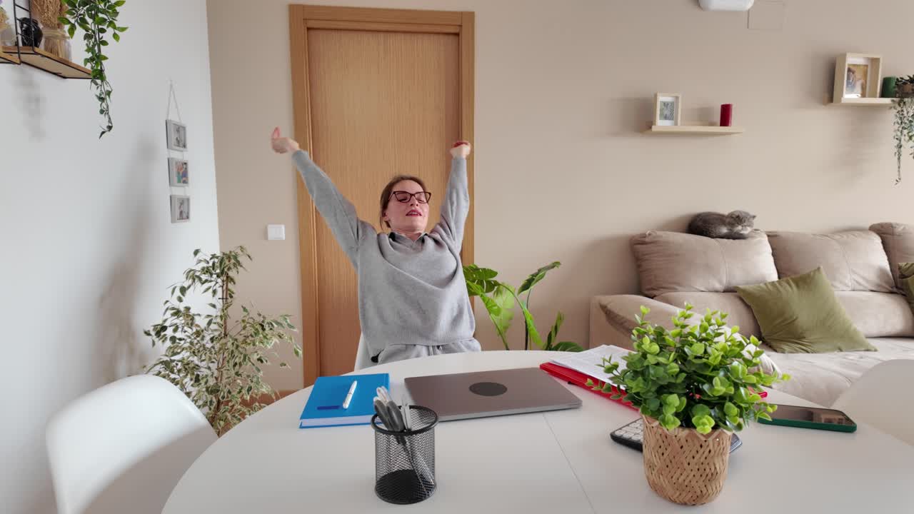 mujer estirándose en la oficina de casa