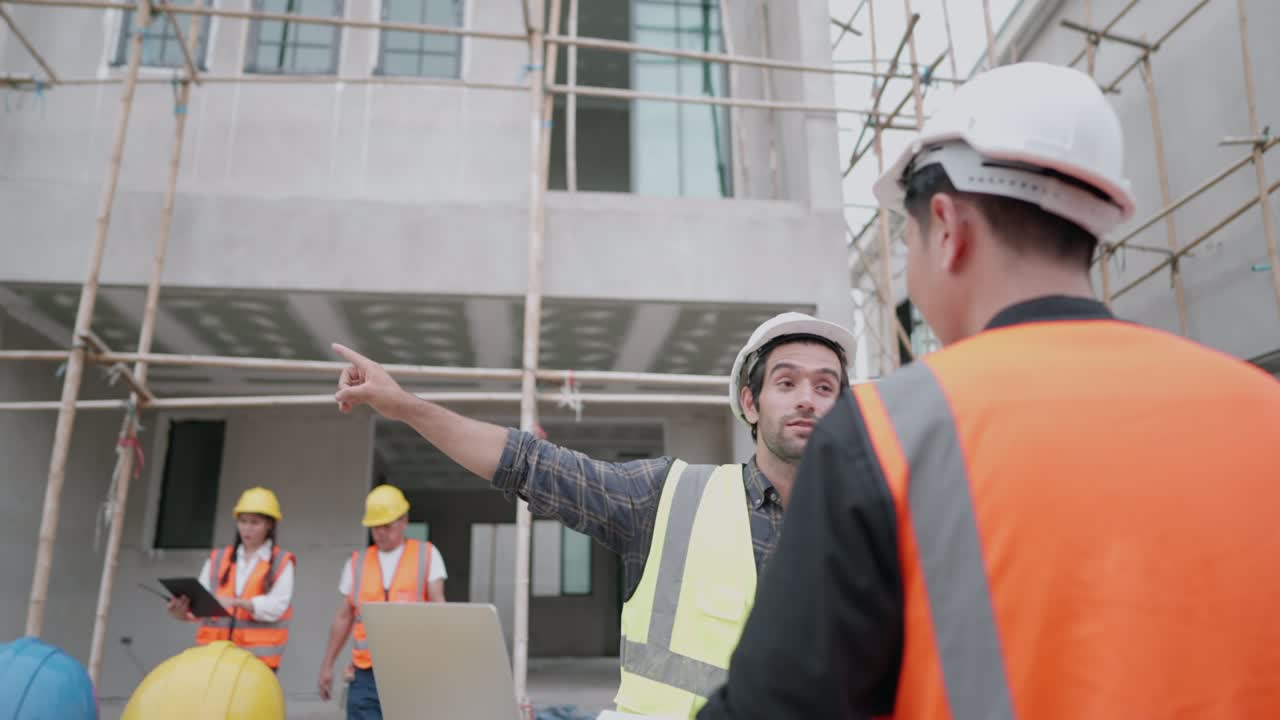 arquitecto masculino caucásico o ingeniero civil hablando con forman sobre el progreso de la construcción de la casa del proyecto de vivienda. un equipo de contratistas profesionales multirraciales está trabajando en el sitio de construcción de viviendas.