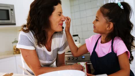 Daughter-and-mother-having-fun-while-preparing-cookies