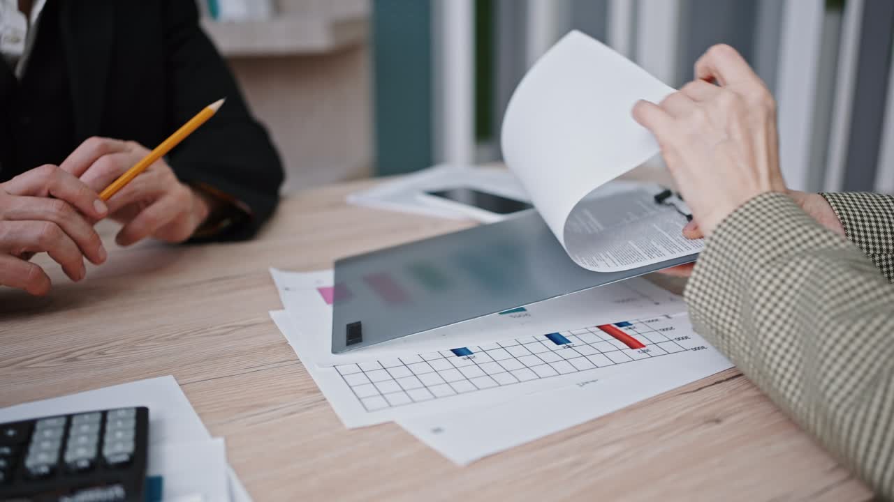papeleo corporativo. imagen de cerca de un hombre y una mujer irreconocibles que trabajan juntos discutiendo detalles del contrato en la oficina.