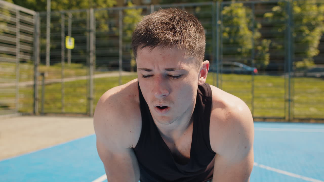 Athletic sport man jogger use smart watch checking heart rate route for running on basketball court