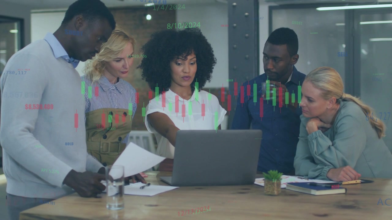 Team leaning in meeting lead pointing initiating finance charts animating on laptop, team deciding
