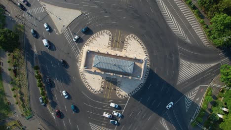 Top-Down-Aerial-Footage-of-the-Arch-of-Triumph-and-Cars-Driving-in-the-Roundabout,-Romania,-Arcul-De-Triumf