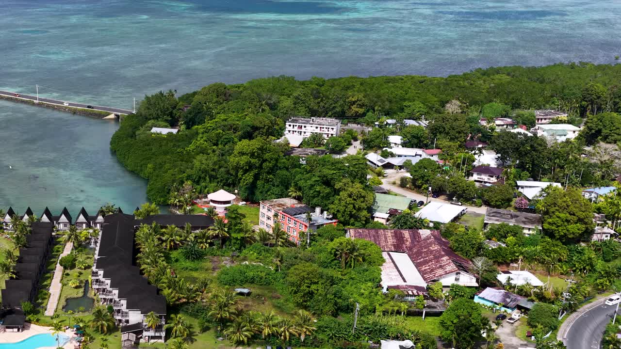 Ripresa aerea con drone dall'alto che riprende un lussureggiante resort tropicale e la costa turchese a Palau.