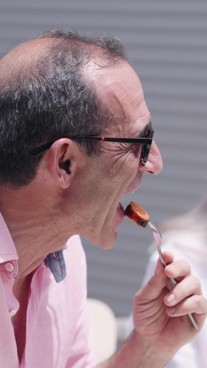 Uomo maturo che mangia all'aperto in un ristorante