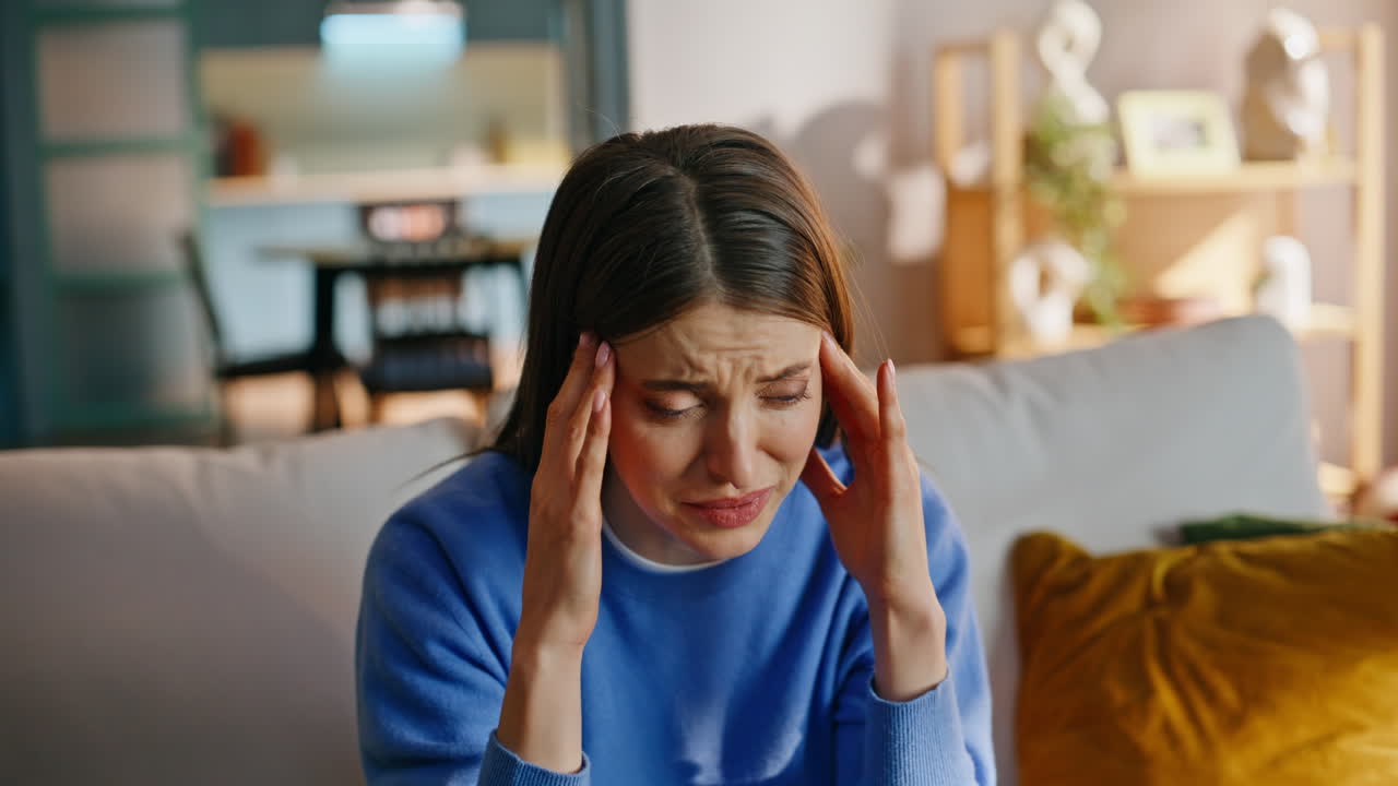 Stressed mother suffering headache active son running living room sofa closeup