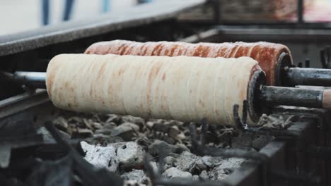 making the hungarian chimney cakes above the glowing ember