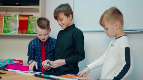 schoolboys playing educative games. elementary school pupils standing in the classroom and talking together. developing study at school.