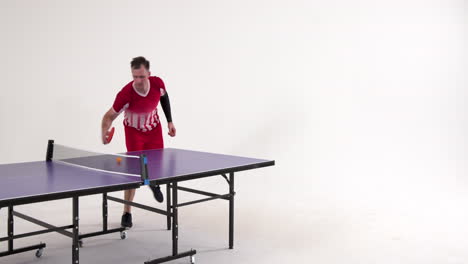 male table tennis player serving and passing the ball on white background, copy space