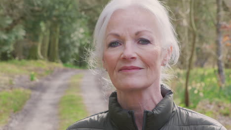 portrait of senior woman on walk in countryside exercising during covid 19 lockdown