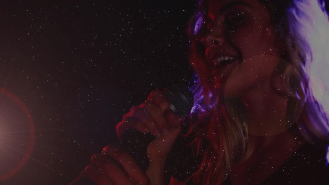 Female singer stepping under musical stage lights, grasping mic and performing emotively