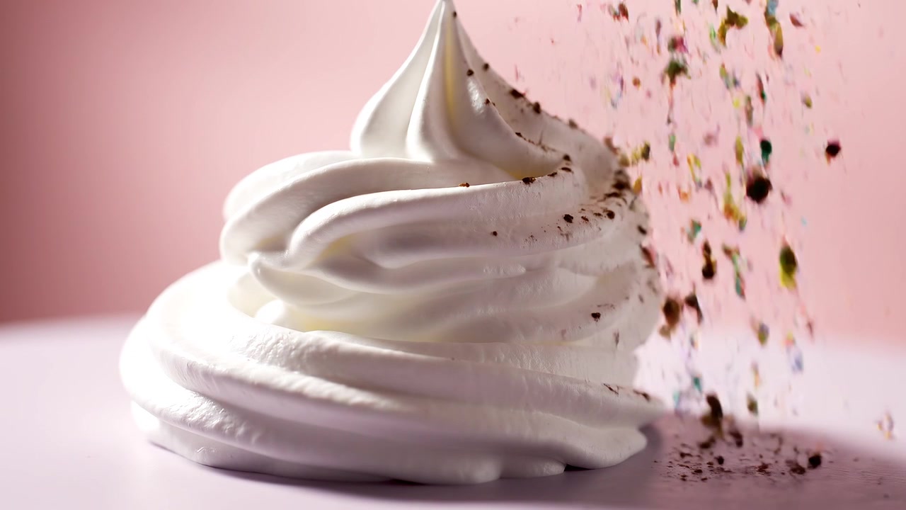 Close-up de chantilly branco sendo aplicado sobre uma superfície