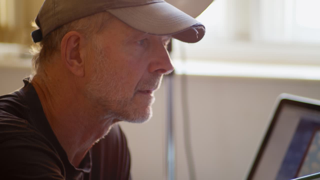 un retratista masculino, sentado de perfil, pinta un lienzo de trabajo