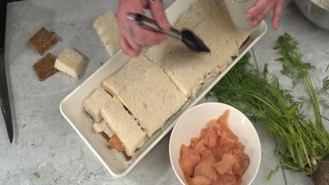 High-angle-food-prep:-Smoked-salmon,-dill-Smorgastarta-sandwich-cake