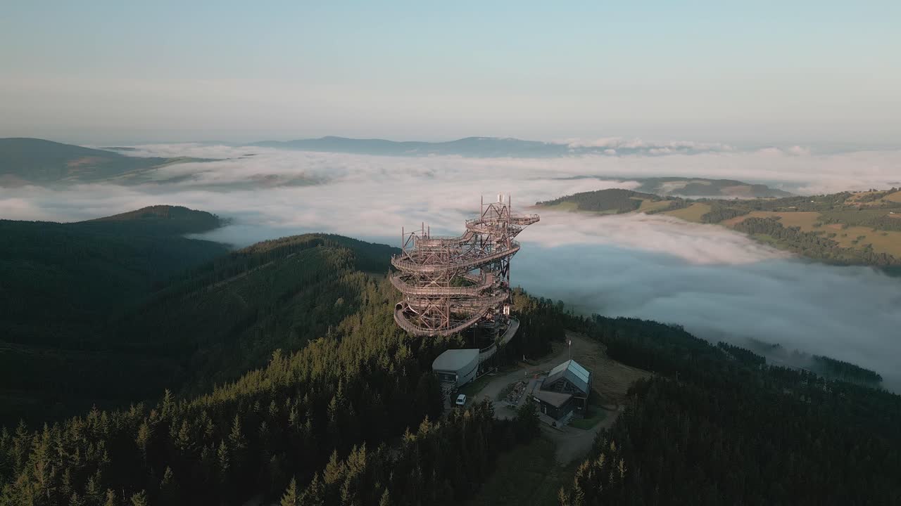 Aerial View of a Tower on a Mountaintop Above the Clouds