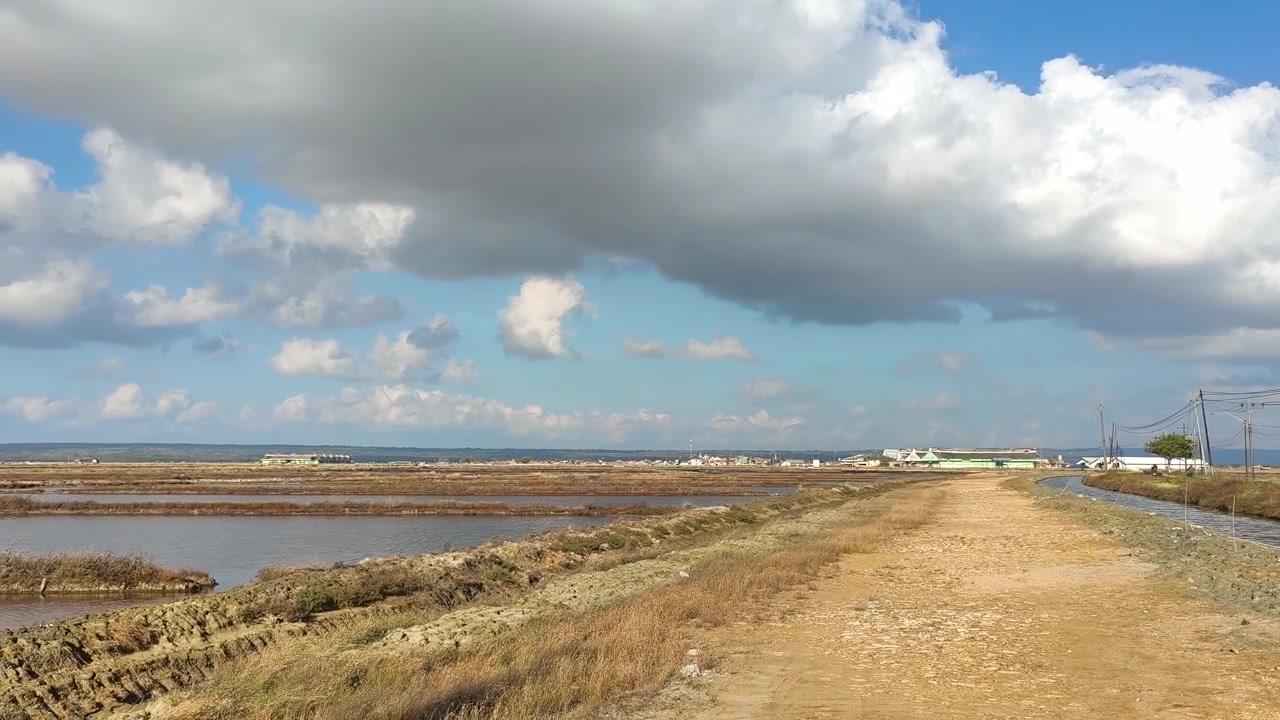 Vista panoramica di saline e paesaggio rurale sotto un cielo nuvoloso