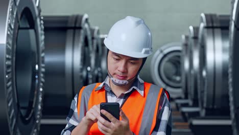 ingeniero usando un teléfono inteligente en una fábrica
