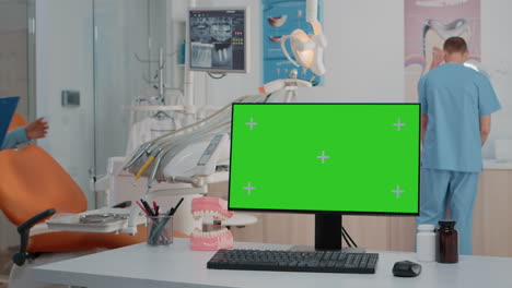 monitor with green screen on desk in dentist office