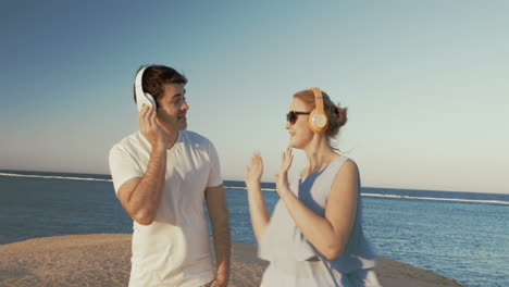 Young-people-in-headphones-relaxing-on-beach