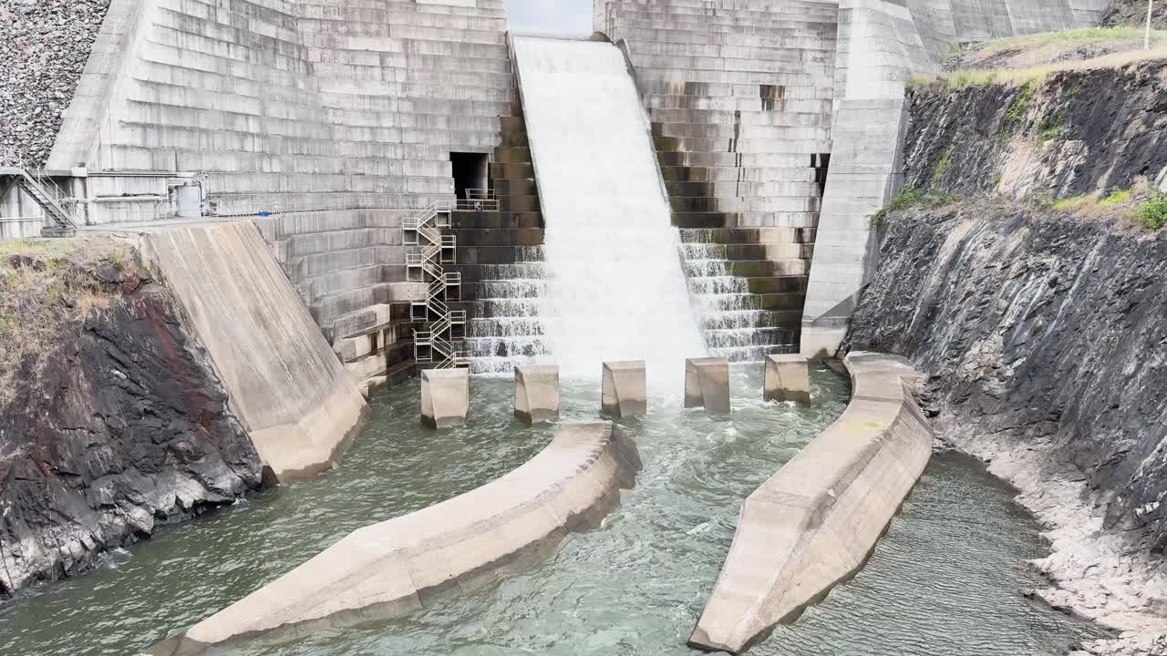 Water flows over dam spillway into river