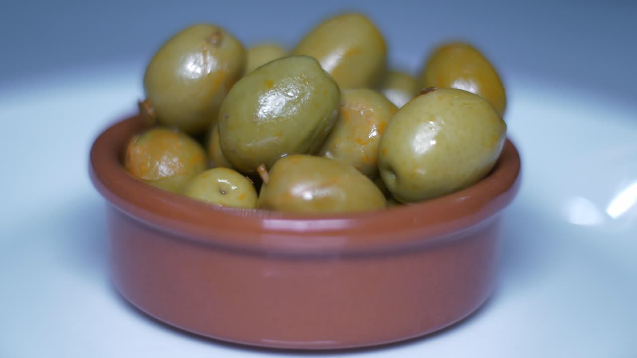 Close-up of a bowl of marinated green olives
