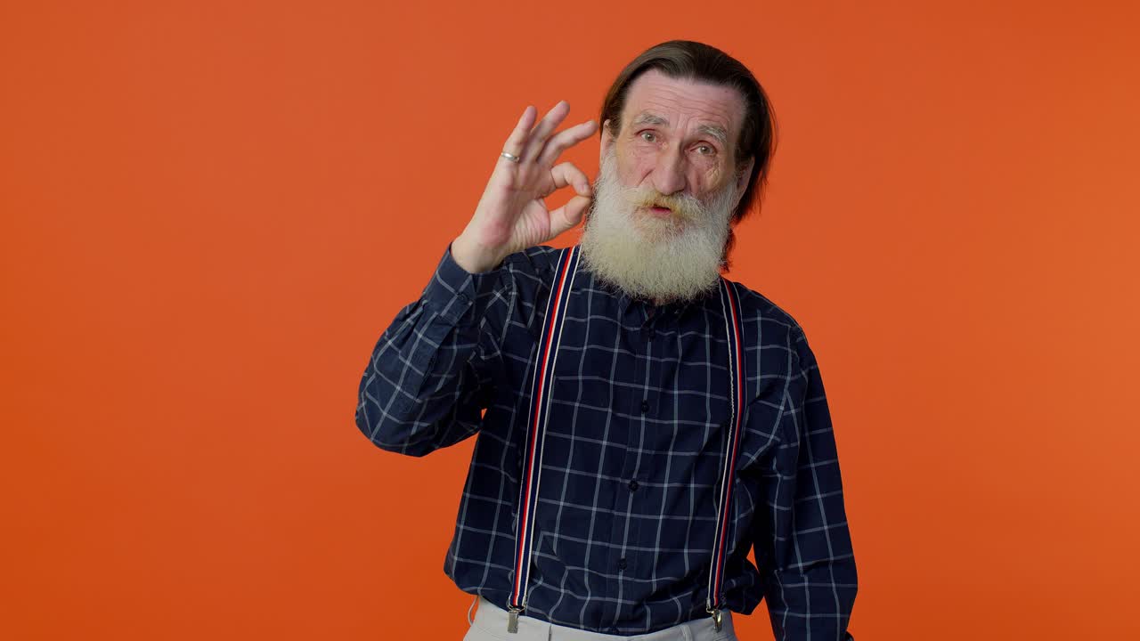 hombre viejo maduro mirando con aprobación a la cámara mostrando ok gesto, como señal positivo algo bueno