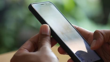 Close-up-video-of-man-hand-using-a-cellular-phone-at-cafe