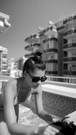 woman working on laptop in a rooftop pool